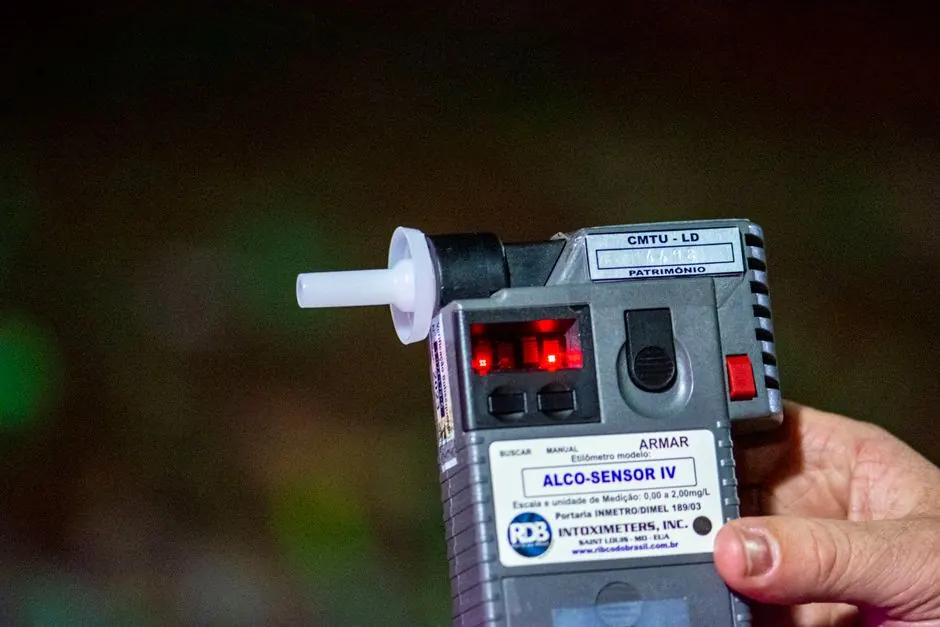 Detailed close-up of Alco-Sensor IV breathalyzer device held by a person outdoors in Londrina, Brazil.